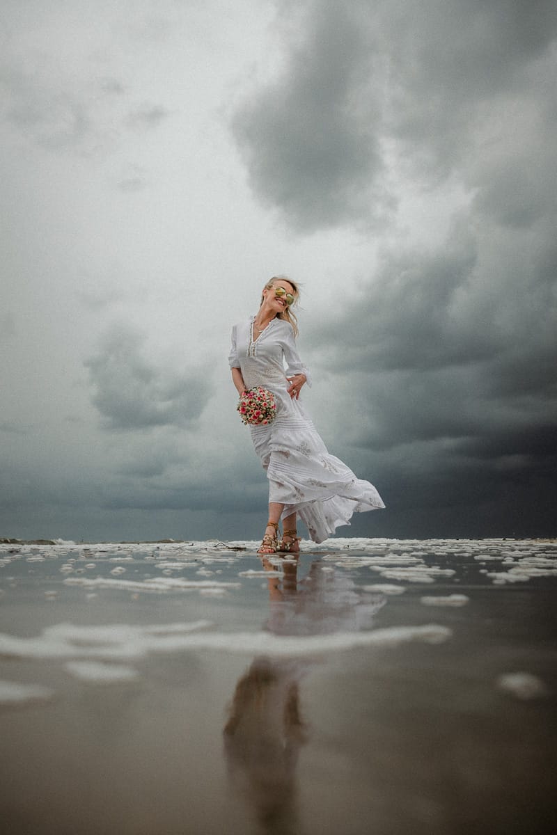 Braut im Bohokleid bei Ihrer Inselhochzeit im Watt von Norderney bei Unwetter.