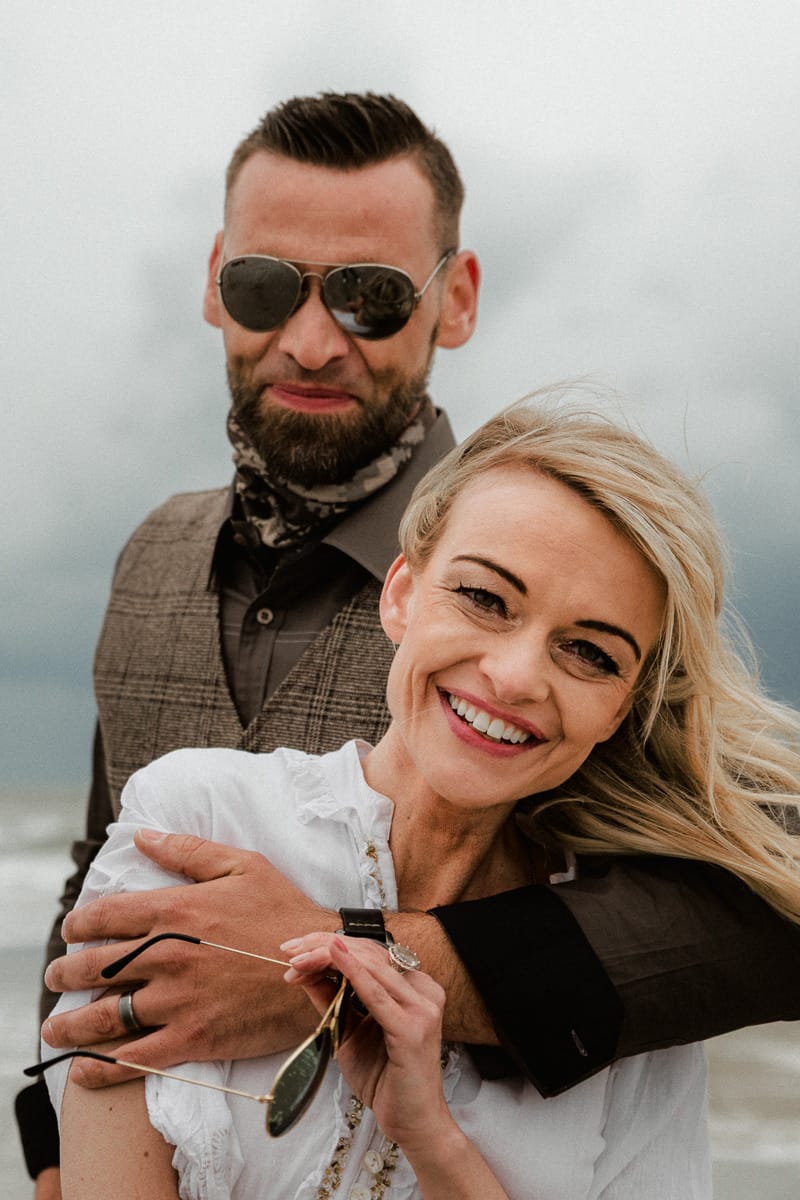 Brautpaar lacht in die Kamera beim Paarshooting ihrer Inselhochzeit.