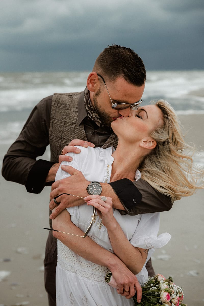 Kuss Pose bei Hochzeits Shooting auf Norderney vor der Nordsee.
