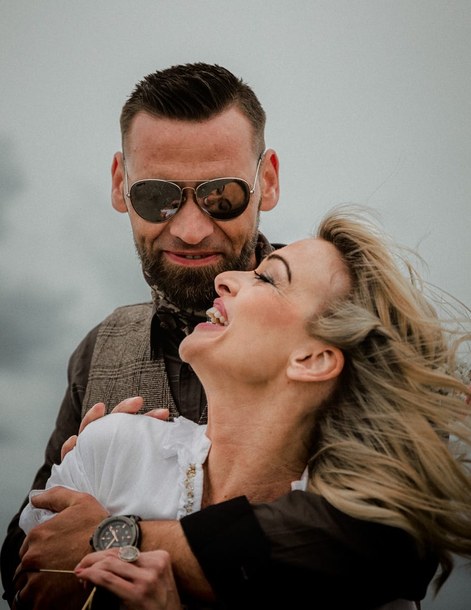 Paar umarmt ich beim Shooting am Strand fuer ein Portraitfoto.