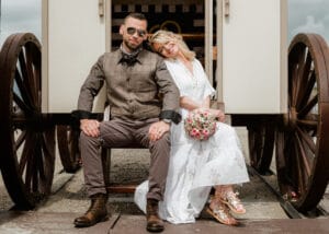Das Hochzeitspaar freut sich ueber die letzten Sonnenstrahlen und sitzt vor dem Standesamt auf Norderney am Strand.