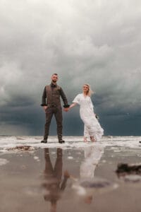Brautpaar unter dramatischem Nordseehimmel auf Norderney von Markus R. Hirsch