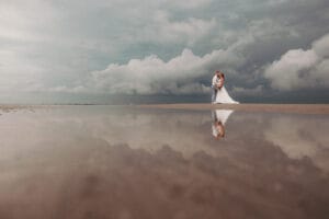 Im Watt spiegelt sich das Hochzeitspaar im Priel auf Norderney von Markus R. Hirsch