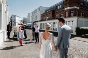 Auf dem Weg durch die Stadt Norderney wird das Paar von ihrer Verwandtschaft fotografiert vor der Villa Rossini.