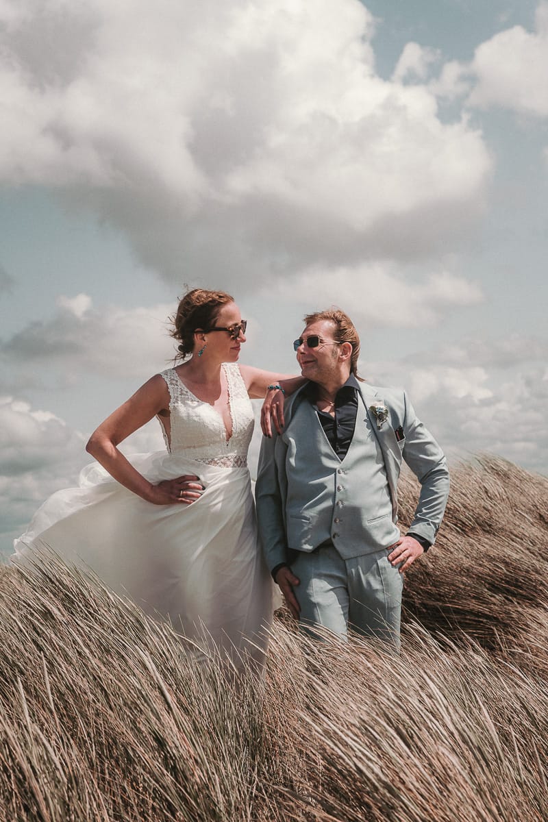 Laessiges Paar bei Ihrem Hochzeitsshootig am Westbad der Insel Norderney im Duenengras.
