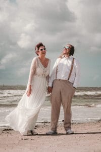 Spassiges Hochzeitspaar auf Norderney nach ihrer Trauzermeonie im Badekarren.